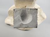a sculpture of a face on a block of cement