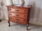 une commode en bois sur laquelle est posé un vase