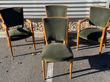 trois chaises vertes posées sur un parking à côté d'un immeuble