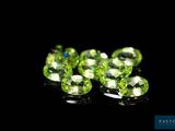 a close up of a bunch of green gems on a black surface