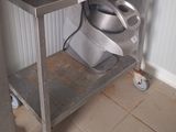 un micro-ondes argenté posé sur une étagère métallique à côté des toilettes