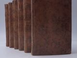 five books lined up in a row on a white surface