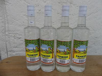 Trois bouteilles de Tanish sont posées sur une table en bois.