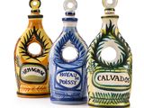 trois bouteilles en céramique de couleurs et de motifs différents posées sur une surface blanche