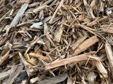 a pile of wood chips on the ground next to a fire hydrant