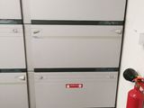 a fire extinguisor next to a stack of filing cabinets