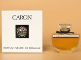 l'image d'un flacon de parfum posé à côté d'une boîte