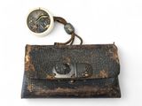 un vieux porte-monnaie en cuir muni d'un fermoir métallique, sur fond blanc