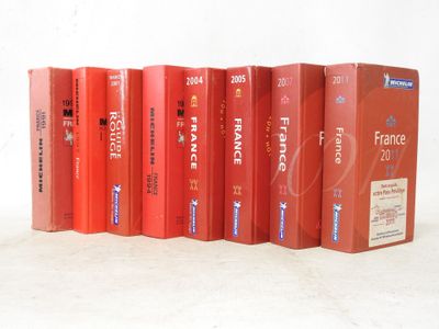 several red books are lined up in a row on a white surface