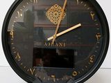 a black clock with gold numbers on it on a table