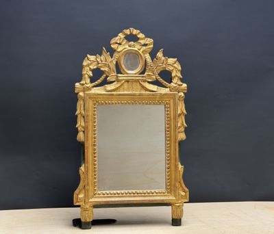 un miroir doré richement décoré, muni d'un cadre et posé sur un socle
