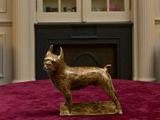 statue d'un chien posée sur une table devant une cheminée
