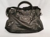 black leather handbag sitting on a white surface with a white background