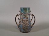 a blue vase with a metal handle on a table