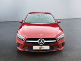 a red mercedes cla parked in front of a white wall
