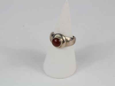 sterling silver ring with a red stone in the middle of it