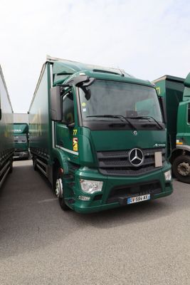 deux camions verts garés l'un à côté de l'autre sur un parking