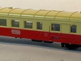 a red and yellow train car on a white surface