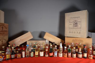 Plusieurs bouteilles d'alcool sont alignées sur une table rouge