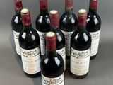 six bottles of red wine are lined up in a row