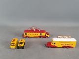 two toy trucks and a fire truck on a table