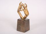 statue of two hands holding each other on a marble block