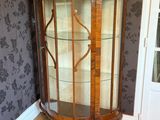a glass display cabinet in the corner of a room