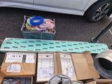 many boxes of electronic equipment on the ground next to a car
