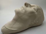 a white sculpture of a man ' s head on a white surface