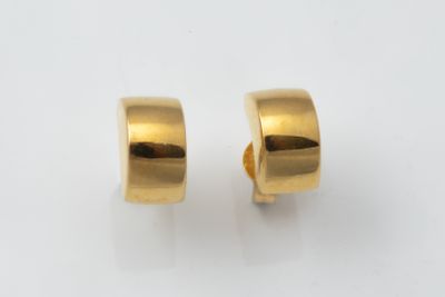a pair of gold hoop earrings on a white surface