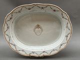 une assiette blanche ornée d'un motif doré et rouge