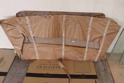 une valise posée par terre à côté de quelques cartons