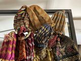 de nombreuses écharpes et bonnets posés sur une table en verre
