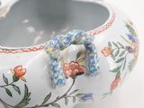a white vase with a floral design on it