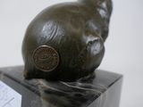a statue of a snail sitting on a marble block