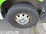 a close up of a tire on the side of a green car