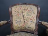 a chair that has a tapestry on it and a clock on the back of it