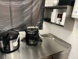 stainless steel counter top in a commercial kitchen with a blender and coffee maker