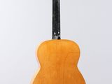 an acoustic guitar hanging from a string on a white background