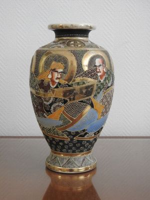 un vase avec un tableau posé sur une table