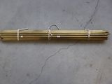 a pair of brass tubes tied together on a concrete surface