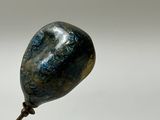 a small metal object with a blue stone on it