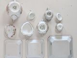 a white table with plates, cups, and a teapot on it