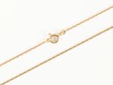 a gold chain with a single pearl on it