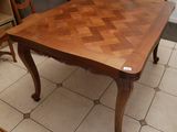 une table en bois avec un plateau à carreaux, posée sur un sol carrelé