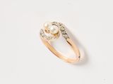 a gold ring with a pearl and diamonds