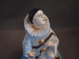 a figurine of a man sitting on a stool