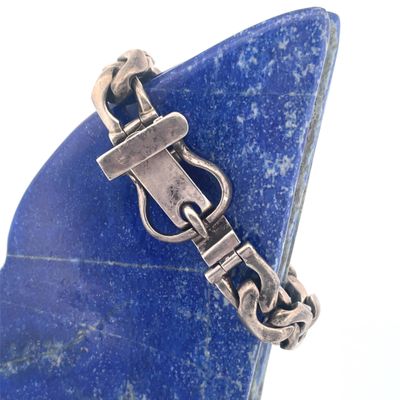 a blue stone with a silver clasp on it