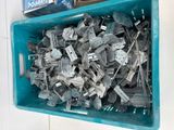 a blue container filled with metal parts on a white wall