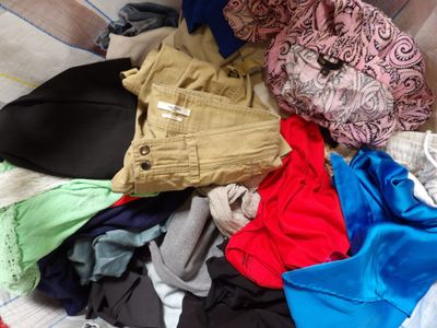 a pile of clothes that is on a bed